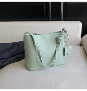 Detailed shot of mint green lychee grain leather bucket bag with heart pendant charm