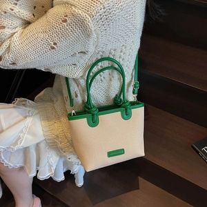Grand sac cabas en paille beige avec bordure en cuir vert et bandoulière réglable