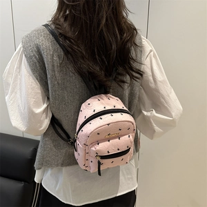 Pink women's mini backpack with butterfly prints and gold 'Fashion' metal tag