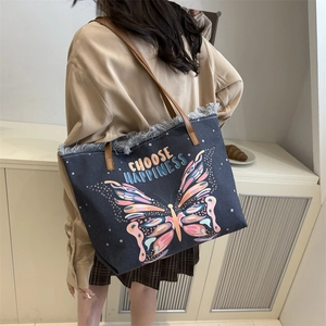 Donkerblauwe denim shopper met kleurrijk vlinderborduurwerk en lederen handvatten