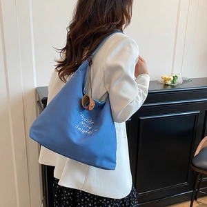 Minimalist sky blue canvas tote bag with white lettering for daily commute or campus