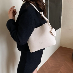 Chic white lychee leather bucket bag for women with crossbody strap and round charm