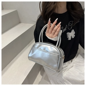 Detailed close-up of metallic silver pillow bag with smooth PU leather and gold buckle