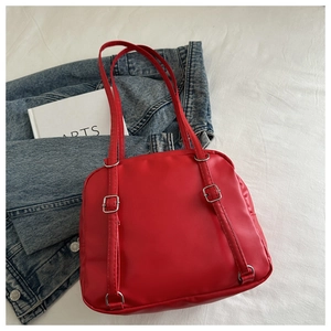 Detail view of red PU leather square bag with silver adjustable buckle and slim strap