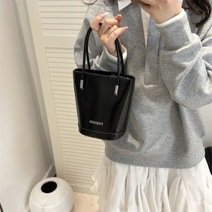 Minimalist black bucket handbag with FASHION print and slim handles for modern women
