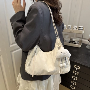 Minimalist beige crescent tote bag with cute cloud charm and silver zipper detailing