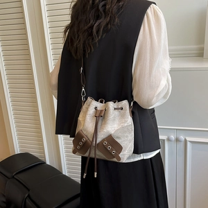 Sac seau vintage en toile avec patchwork de cuir porté par un mannequin