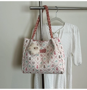 Detail of quilted tote bag featuring rabbit floral print and plush star charm accessory