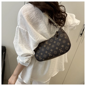 Détail du sac sous le bras élégant avec motif vintage et chaîne dorée sur mannequin