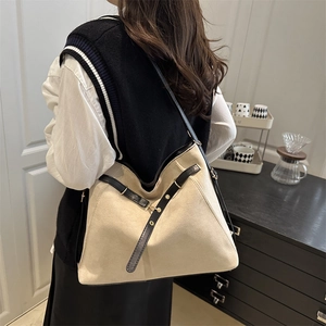 Grand sac cabas minimaliste crème avec lanières en cuir noir porté à l'épaule