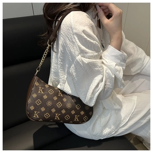Détail du sac sous le bras monogramme marron vintage avec chaîne dorée sur un mannequin