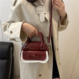 Borsa a mano retrò bordeaux con fiocco e pizzo indossata con un classico trench