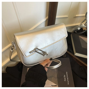 Macro detail of silver saddle bag showing metallic leather texture and unique metal clasp