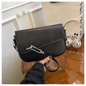 Detail of black matte saddle bag featuring a unique silver chain metal buckle closure