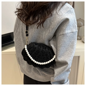 Close-up of a black velvet shell crossbody bag with leopard print and pearl decoration