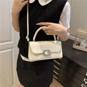 Petit sac carré blanc en cuir verni avec boucle argentée G porté par un modèle