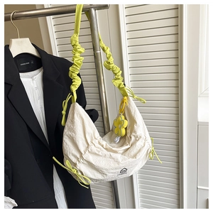 Détail du sac à cordon crème avec bandoulière froncée verte et charm tournesol