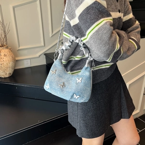 Blue denim underarm bag with silver butterfly charms and pleated strap detail