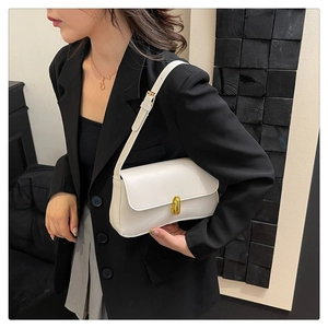 Detail of white leather shoulder bag with elegant golden metal twist lock and slim strap