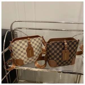 Close-up of retro monogram bucket bags in beige and brown with woven fashion straps