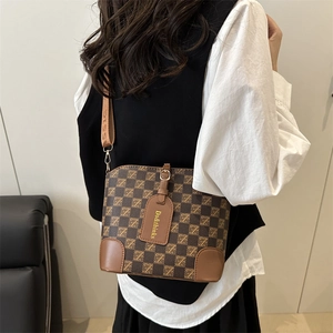 Women's brown checkerboard pattern crossbody bucket bag with wide adjustable shoulder strap