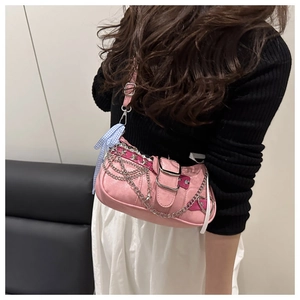 Pink Y2K shoulder bag featuring silver chains, star studs, and blue checkered bow detail