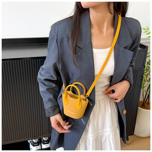 Dettaglio mini borsa a secchiello gialla in pelle martellata con scritta stampata