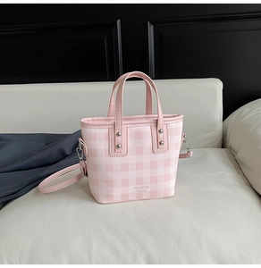 Détail du sac seau à carreaux rose et blanc avec imprimé TIANYUN YICAI et rivets argentés