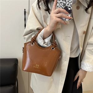 Schicke braune Eimer-Tasche aus Lackleder für Damen mit Metallring und Knotengriff-Detail