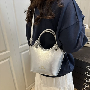 Minimalistische silberne Beuteltasche mit Metallic-Finish und runden Griffen im Haus