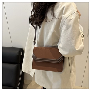 Brown suede flap crossbody bag shown on model to demonstrate size and styling for women