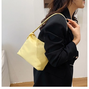 Vista laterale di una borsa sottobraccio in nylon giallo chiaro con design minimalista