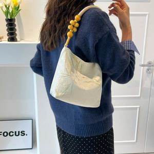 Borsa a mano ricamata in stile cinese con manico di perle e motivi floreali dorati