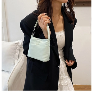 Dettaglio della borsa in nylon verde menta con scritta enjoy life a rilievo e ganci