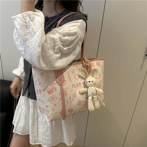 Chic cream tote bag with pink graffiti patterns and a cute plush rabbit pendant charm