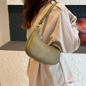 Fashionable olive green suede crescent bag shown as a sleek underarm handbag for women