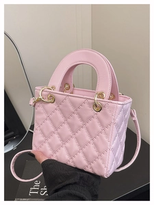 Detailed view of pink quilted PU leather handbag with elegant gold-tone hardware loops