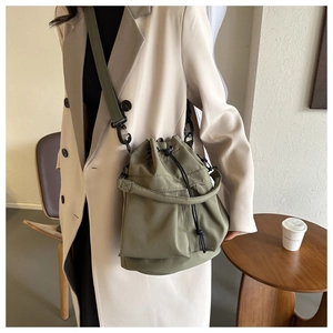 Détail du sac seau en nylon vert olive avec cordon de serrage et crochets métalliques