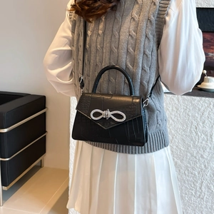 Borsa a mano nera con motivo a coccodrillo e fibbia a fiocco in cristallo da donna