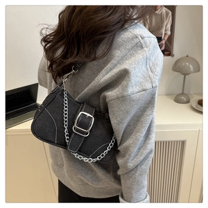 Detailaufnahme der dunkelgrauen Denim-Umhängetasche mit weißen Kontrastnähten und Metallkette