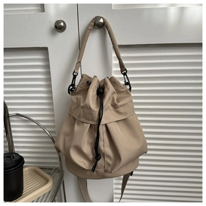 Détail du sac seau en nylon kaki avec cordon de serrage et texture plissée
