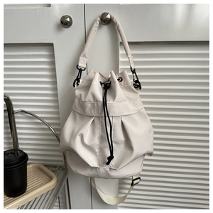 Détail du sac seau en nylon crème avec fermeture à cordon et garnitures noires mates