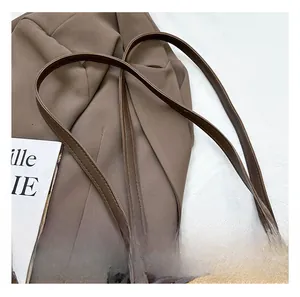 Vue détaillée de la bandoulière en cuir marron et du grain de litchi sur le sac cabas