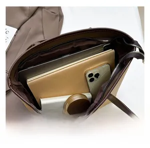 Détail de l'intérieur spacieux du sac cabas en cuir marron avec double fermeture éclair métal