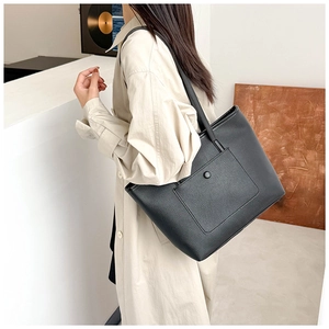 Détail du grand sac cabas noir en similicuir avec boucle décorative et texture grainée