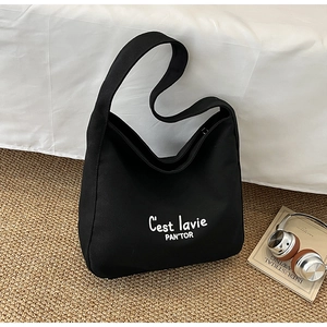 Detail of black canvas hobo bag featuring white cursive print on woven texture