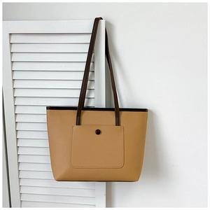 Détail d'un sac cabas en cuir grainé bicolore avec texture élégante et poche à bouton pression