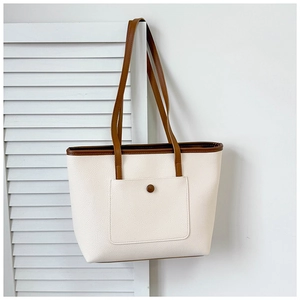 Vue détaillée du sac cabas bicolore avec texture grainée et poche frontale décorative