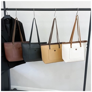 Détail de grands sacs cabas en quatre couleurs avec poche frontale et texture en cuir grainé