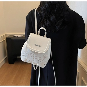 Close-up of white PU leather backpack with cartoon cat print and woven chain detail